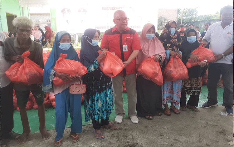 Kepala Dinas Ketahanan Pangan Provinsi Kalteng Riza Rahmadi menyerahkan bantuan bahan pokok subsidi secara simbolis. (FOTO: IST)