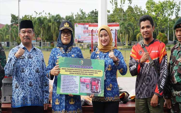 Sekda Palangka Raya Hera Nugrahayu menyerahkan Sarpras pencegahan Karhutla kepada lurah menteng. (FOTO: HENDRI)