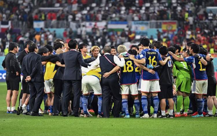 Para pemain dan ofisial Jepang merayakan keberhasilannya mencapai 16 besar setelah untuk kedua kalinya menumbangkan raksasa sepak bola dunia yang kali ini giliran Spanyol yang menjadi korban berikutnya Samurai Biru dalam pertandingan terakhir Grup E di Stadion Khalifa International, Doha, Qatar, Kamis 1 Desember 2022. (AFP/PHILIP FONG)