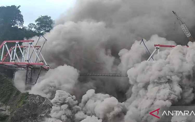 Luncuran Awan Panas Guguran (APG) Gunungapi Semeru menerjang Jembatan Gladak Perak di Lumajang, Jawa Timur, Minggu (4/12/2022). ANTARA FOTO/Dok BNPB/Zk/YU (ANTARA FOTO/ZABUR_KARURU)