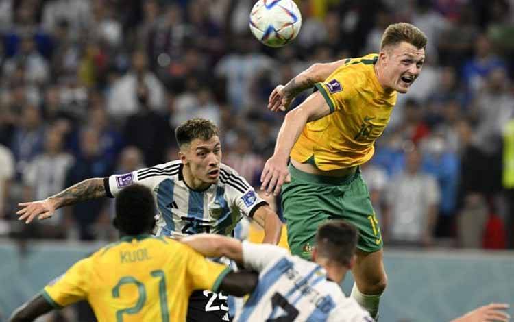 Bek Australia Harry Souttar (atas) beraksi dalam pertandingan babak 16 besar Piala Dunia 2022 antara Argentina dan Australia di Stadion Ahmad Bin Ali di Al-Rayyan, Doha, 3 Desember 2022. (AFP/ALFREDO ESTRELLA)