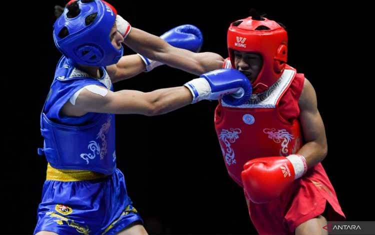 Atlet wushu Indonesia Denis Darmawan (kanan) bertarung melawan atlet wushu Algeria Merah Abdelouahab (kiri) dalam pertandingan perempat final nomor Sanda kelompok 52 kilogram putra Kejuaraan Dunia Wushu Junior 2022 di ICE BSD, Tangerang, Banten, Kamis (8/12/2022). Denis Darmawan melangkah ke semifinal usai mengalahkan Merah Abdelouahab dengan skor 2-0. ANTARA FOTO/Fauzan/YU (ANTARA FOTO/FAUZAN)