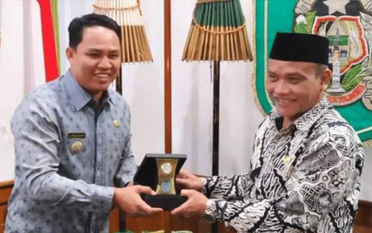 Bupati Lamandau Hendra Lesmana menerima cinderamata dari? Walikota Yogyakarta, Sumadi.(FOTO : HENDI NURFALAH)