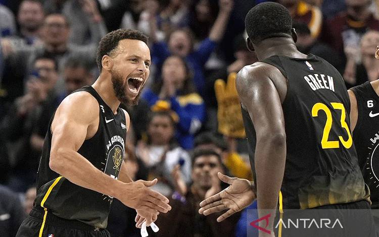 Arsip - Bintang Golden State Warriors Stephen Curry (kiri) berselebrasi bersama Draymond Green seusai melesakkan tripoin krusial melawan Cleveland Cavaliers dalam lanjutan NBA di Chase Center, California, Amerika Serikat, Jumat (11/11/2022) waktu setempat. (ANTARA/AFP/GETTY IMAGES/Thearon W. Henderson)