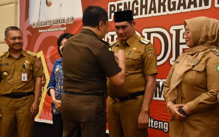 Pj. Bupati Kobar Anang Dirjo saat menerima Penghargaan Penghargaan Siddhakarya 2022? secara langsung dari Asisten Pemerintahan dan Kesejahteraan Rakyat Katma F. Dirun yang mewakili Gubernur Kalteng, Selasa, 27 Desember 2022