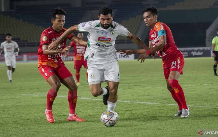 Pesepak bola PSS Sleman Jihad Ayoub (tengah) berusaha melewati hadangan pesepak bola Bali United FC Fadil (kanan) dan Rahmat (kiri) pada pertandingan BRI Liga 1 di Stadion Manahan, Solo, Jawa Tengah, Senin (19/12/2022). . ANTARA FOTO/Mohammad Ayudha/tom. (ANTARA FOTO/MOHAMMAD AYUDHA)