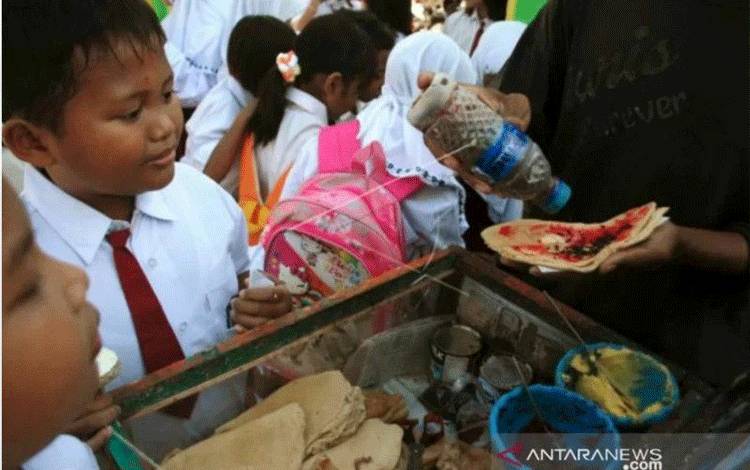 Ilustrasi - Dua siswa membeli jajanan pinggir jalan pada hari pertama masuk sekolah di SDN Negeri 3, Bugih, Pamekasan, Jatim, Senin (9/7/12). Badan Pengawas Obat dan Makanan (BPOM) mengingatkan masyarakat untuk mewaspadai jajanan anak yang dijajakan karena ditengarai banyak mengandung bahan kimia yang membahayakan kesehatan. (FOTO ANTARA/Saiful Bahri/Koz/Spt/12).