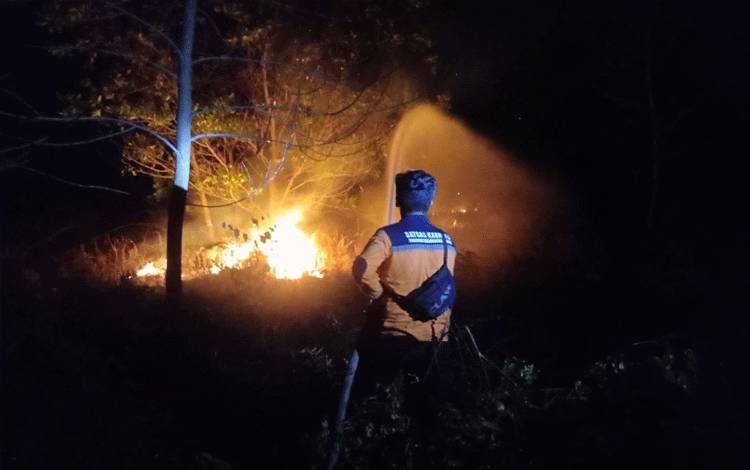 Petugas BPBD Kota Palangka Raya memadamkan api saat kejadian Karhutla (FOTO : IST*?