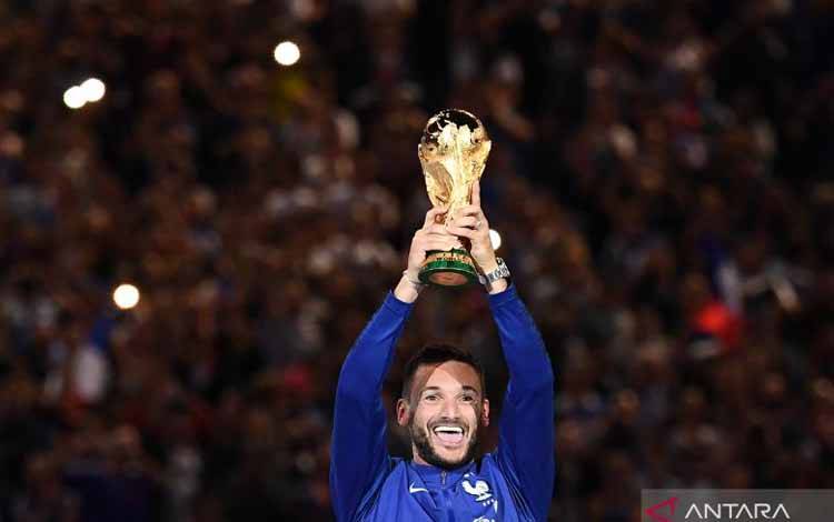 Hugo Lloris mengangkat trofi Piala Dunia 2018 setelah mengalahkan Kroasia di laga final di Rusia pada 9 September 2020. Kiper Tottenham Hotspur tersebut mengumumkan dari sepak bola internasional pada 10 Januari 2023. ANTARA/AFP/ANNE-CHRISTINE POUJOULAT