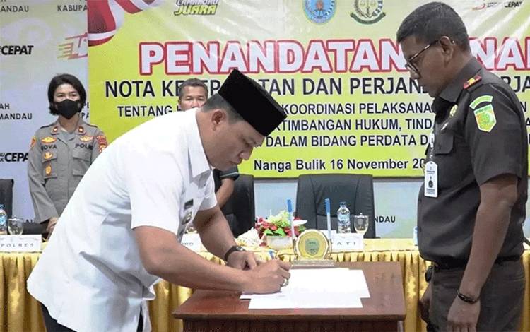 Bupati Lamandau Hendra Lesmana menandatangani MoU tentang kerjasama di bidang hukum Perdata dan Tata Usaha Negara. (FOTO : HENDI NURFALAH)