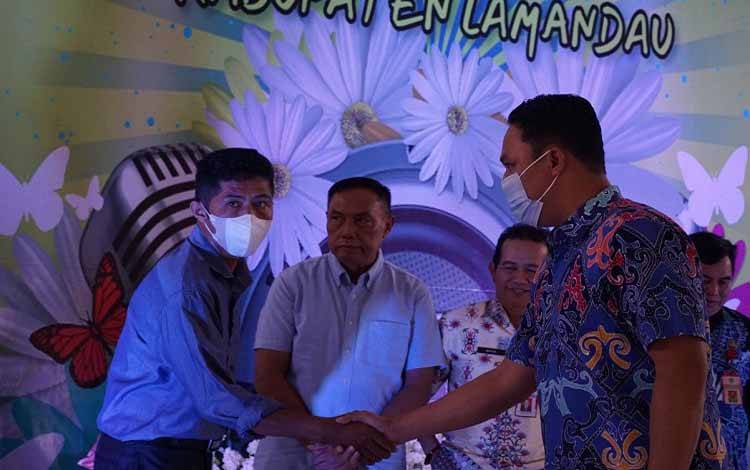 Bupati Lamandau Hendra Lesmana menyalami salah satu peserta lomba menyanyikan lagu rohani. (FOTO : HENDI NURFALAH)