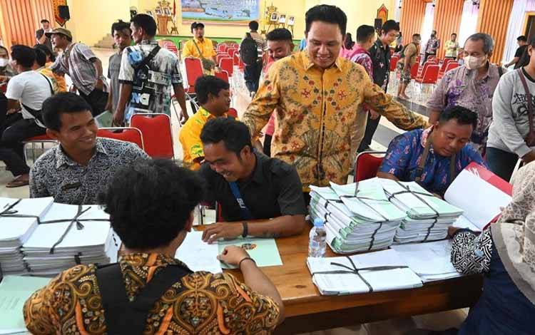 Bupati Lamandau Hendra Lesmana memantau pembagian sertifikat tanah program PTSL. (FOTO: HENDI NURFALAH)