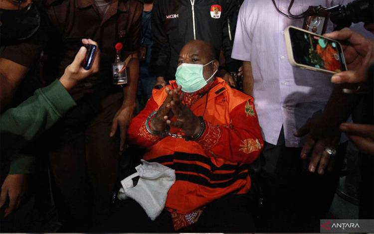 Tersangka Gubernur Papua Lukas Enembe (tengah) yang duduk di kursi roda dikawal petugas menuju mobil tahanan usai menjalani pemeriksaan di Gedung Merah Putih KPK, Jakarta, Kamis (12/1/2023). . ANTARA FOTO/Reno Esnir/aww. (ANTARA FOTO/RENO ESNIR)