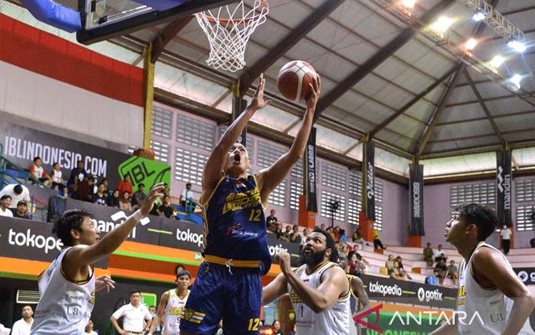 Pebasket Satya Wacana Salatiga Henry Cornelis Lakay (kedua kiri) memasukkan bola yang dihadang sejumlah pemain Elang Pacific Caesar Surabaya saat pertandingan Indonesian Basketball League (IBL) 2023 di GOR Merpati, Denpasar, Bali, Minggu (15/1/2023). Elang Pacific Caesar Surabaya berhasil mengalahkan Satya Wacana Salatiga dengan skor 88-68. ANTARA FOTO/Fikri Yusuf/aww.