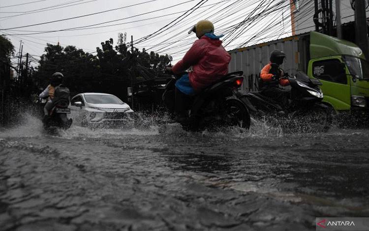 Pengendara kendaraan bermotor melintasi genangan banjir di kawasan Duren Tiga, Jakarta, Rabu (4/1/2023). ANTARA FOTO/Indrianto Eko Suwarso/hp.