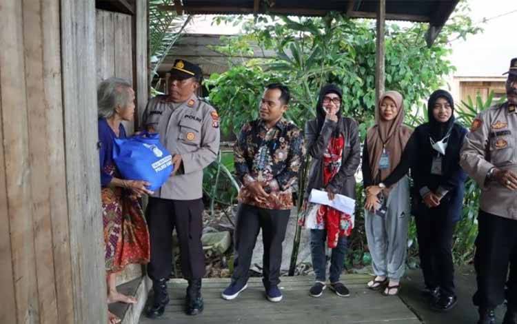 Personel Polres Kapuas saat menyerahkan sembako untuk warga di Desa Pulau Telo pada Jumat, 20 Januari 2023. (FOTO: POLRES KAPUAS)