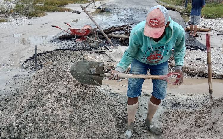 Perbaikan jalan Kabupaten di perbatasan Kelurahan Tampang Tumbang Anjir dan Desa Tanjung Riu Kecamatan Kurun, Sabtu, 21 Januari 2023. (FOTO: RISKA YULYANA)