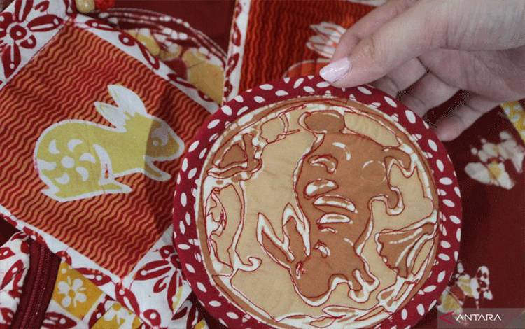 Perajin menata dompet yang dibuat dari kain batik motif shio untuk dijual sebagai bingkisan Imlek di rumah produksi Batik Shio, Purwantoro, Malang, Jawa Timur, Senin (16/1/2023). . ANTARA FOTO/Ari Bowo Sucipto/rwa. (ARI BOWO SUCIPTO/ARI BOWO SUCIPTO)