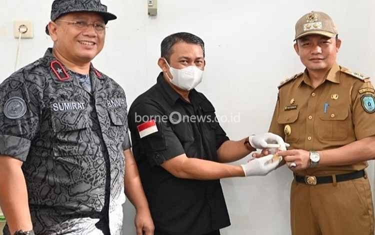 Ketua BNK Lamandau Riko Porwanto (kanan) menyerahkan urine miliknya untuk dilakukan tes narkoba. (FOTO : HENDI NURFALAH)