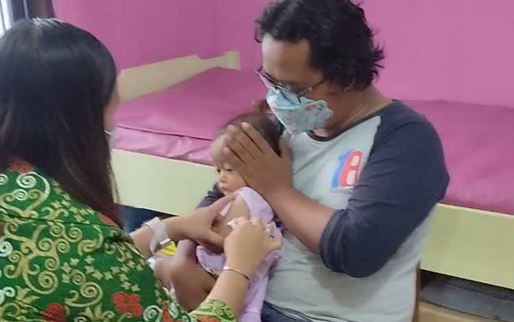 Seorang balita sedang menerima imunisasi dari kader yang ada di Puskesmas Kayon, Palangka Raya. (FOTO: TESTI PRISCILLA)