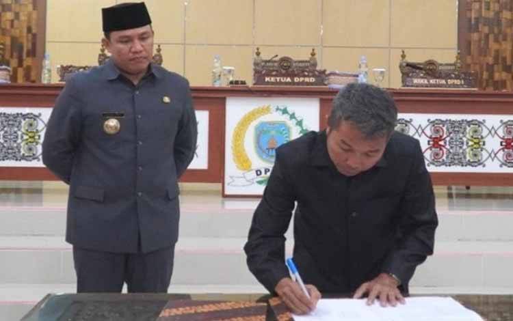 Ketua DPRD Kabupaten Lamandau Herianto Gerzon menandatangani dokumen Ranperda usai Rapat Paripurna masa persidangan II tahun sidang 2022/2023. (FOTO : HENDI NURFALAH)
