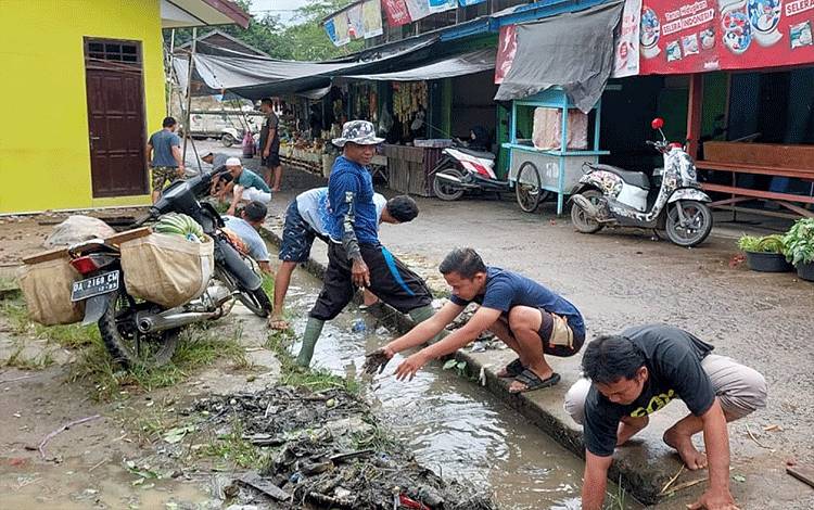 RGB-33 Ampah bersama warga membersihkan selokan di area Pasar Beringin Ampah Kabupaten Barito Timur, Sabtu, 4 Februari 2023. (FOTO: BOLE MALO)