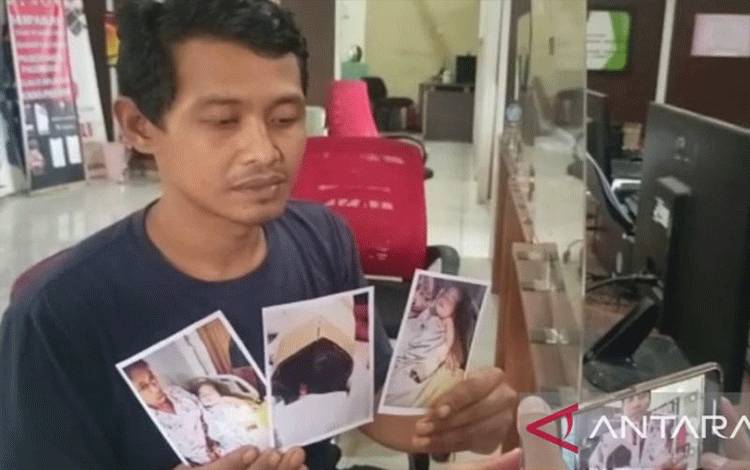 Suparman (38), menunjukkan foto putranya berusia delapan bulan yang jari tangan bagian kelingkingnya diduga digunting oknum perawat rumah sakit Muhammadiyah Palembang saat membuat laporan di SPKT Kepolisian Resor Kota Besar Palembang, Sumatera Selatan, Sabtu (4/2/2023). (ANTARA/M Riezko Bima Elko P)