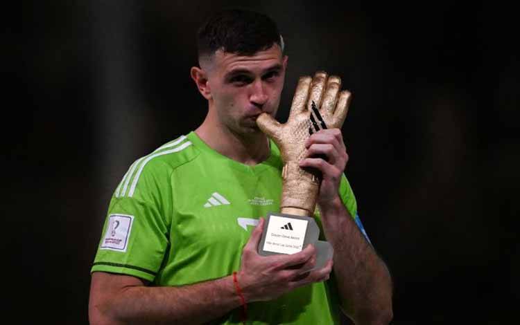 Kiper Argentina Emiliano Martinez poses saat meraih penghargaan Sarung Tangan emas FIFA seusai final Piala Dunia Qatar 2022 di Lusail Stadium, Doha, pada 18 December 2022. (Photo by Kirill KUDRYAVTSEV / AFP) (AFP/KIRILL KUDRYAVTSEV)