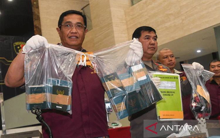 Direktur Tindak Pidana Umum Bareskrim Polri Brigjen Polisi Djuhandhani Rahardjo Puro (kiri) memperlihatkan barang bukti paspor dalam rilis di Bareskrim Polri, Jakarta, Jumat (10/2/2023). ANTARA/Laily Rahmawaty