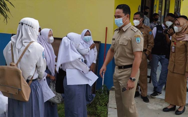 Bupati Lamandau Hendra Lesmana menyapa sejumlah siswi di SMKN 1 Bulik. (FOTO : HENDI NURFALAH)