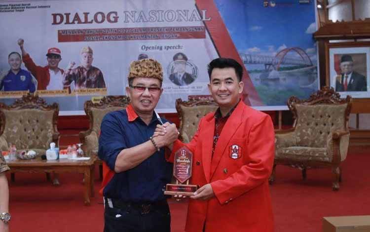 Dr Andrie Elia Embang (kiri) menerima penghargaan dari GDPD GMNI Kalteng, Jumat, 17 Februari 2023. (FOTO: ISTIMEWA)