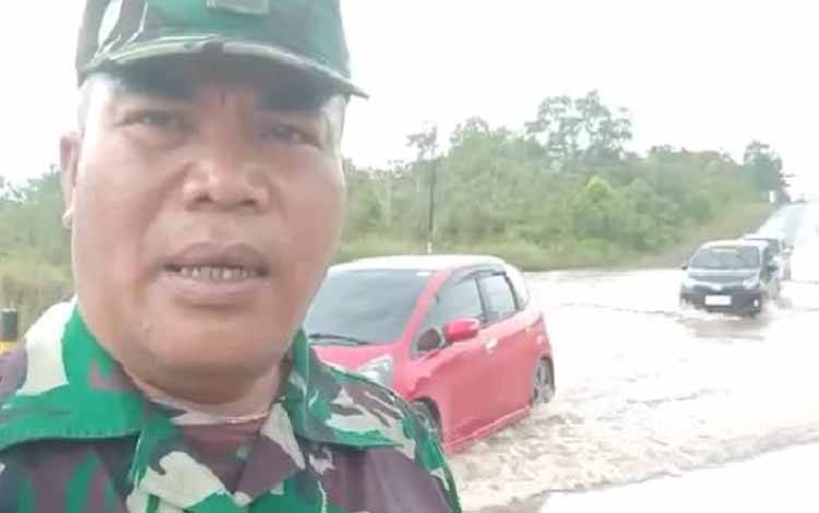 Seorang aparat TNI dari Kodim 1019 Katingan mengatur arus lalulintas di Jalan Trans Kakimantan Km 18, 5 Kereng Pangi - Sampit yang tergenang akibat hujan lebat, Selasa, 28 Februari 2023