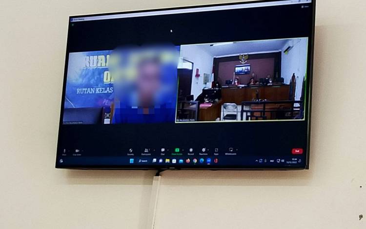 Terdakwa saat menjalani sidang virtual di Pengadilan Negeri Palangka Raya. (FOTO: APRIANDO)