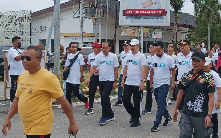 Bupati Gunung Mas Jaya S Monong (topi putih) bersama masyarakat setempat saat mengikuti jalan sehat bersama BUMN, Minggu, 12 Maret 2023.(FOTO: RISKA YULYANA)