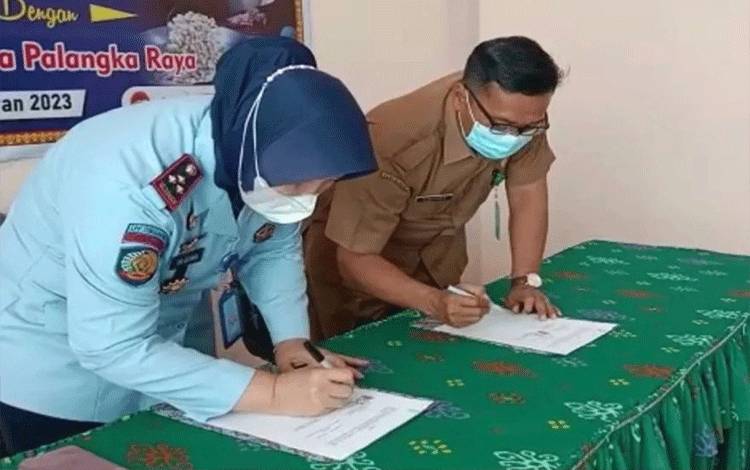 Kepala Lapas Perempuan Kelas IIA Palangka Raya Sri Astiana bersama Sekretaris Dinas Perikanan Kota Palangka Raya Sugiyanto saat melakukan penandatanganan bersama (FOTO : LAPAS PEREMPUAN KELAS IIA PALANGKA RAYA)