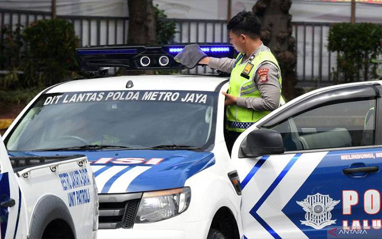Polisi lalu lintas membersihkan kamera sistem tilang elektronik (ETLE) Mobile yang terpasang pada salah satu kendaraan patroli di Mapolda Metro Jaya, Jakarta, Selasa (13/12/2022). ANTARA FOTO/Aditya Pradana Putra/aww.