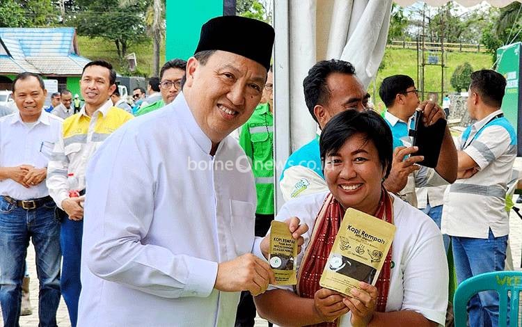 Yery bersama Presiden Direktur Adaro Energy Garibaldi Thohir menunjukkan kopi rempah pasak bumi pada acara Launching Online Store UMKM Adaro Go Digital di Kabupaten Tabalong, Jumat, 17 Maret 2023. (FOTO: BOLE MALO)