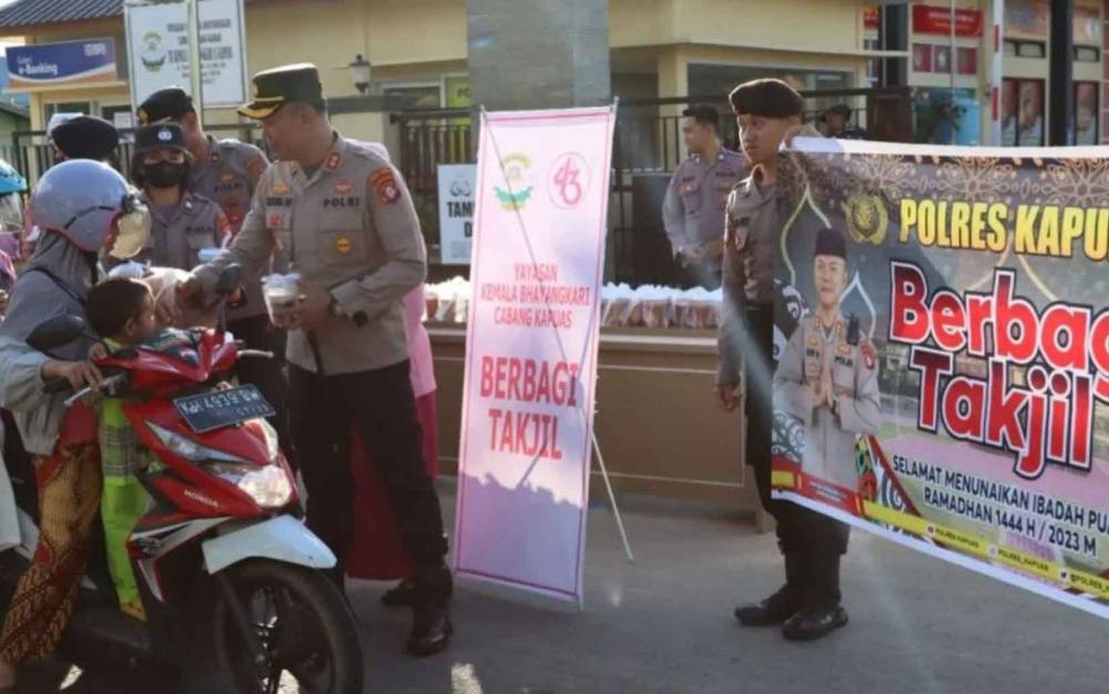 Kapolres Kapuas AKBP Qori Wicaksono saat membagikan takjil kepada pengendara melintas di depan Mapolres setempat. (FOTO: IST)