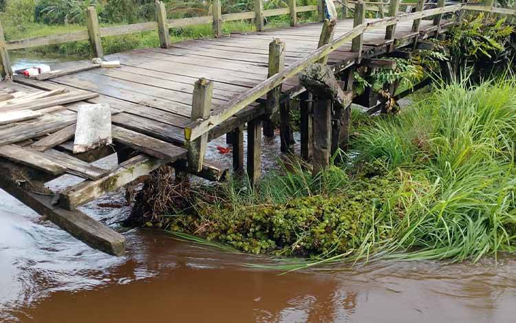 Kondisi jembatan penghubung Mahang-Beriut di Kelurahan Kuala Pembuang 1, nyaris ambruk tergerus arus sungai akibat hujan yang terus terjadi dalam beberapa hari terakhir. (FOTO: IST)