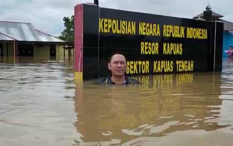 Kapolsek Kapuas Tengah, Iptu Rahmad Tuah saat melaporkan kondisi banjir di sekitar Makopolsek setempat, Kamis, 30 Maret 2023. (FOTO: IST)