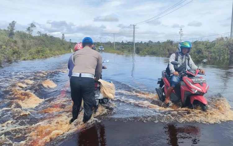 Personel Satlantas Polres Kapuas Bantu Pengendara Motor Terjebak Banjir