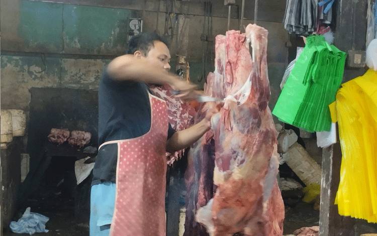 Pedagang sedang memotong lebih kecil bagian daging sapi untuk dijual di Pasar Besar, Palangka Raya.(FOTO: TESTI PRISCILLA)