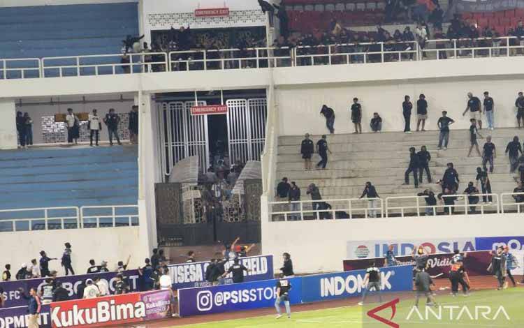 Pendukung PSIS Semarang dan PSS Sleman terlibat saling lempar saat pertandingan di Stadion Jatidiri Semarang, Minggu (2/4/2023) malam. ANTARA/ I.C.Senjaya