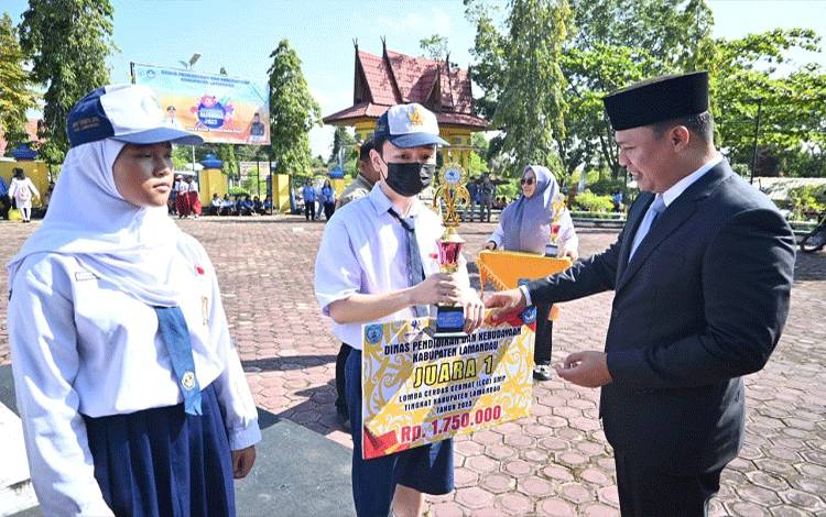 Usai memimpin upacara peringatan Hardiknas Tahun 2023, Bupati Lamandau, Hendra Lesmana menyerahkan penghargaan kepada siswa siswi berprestasi (FOTO : HENDI NURFALAH)