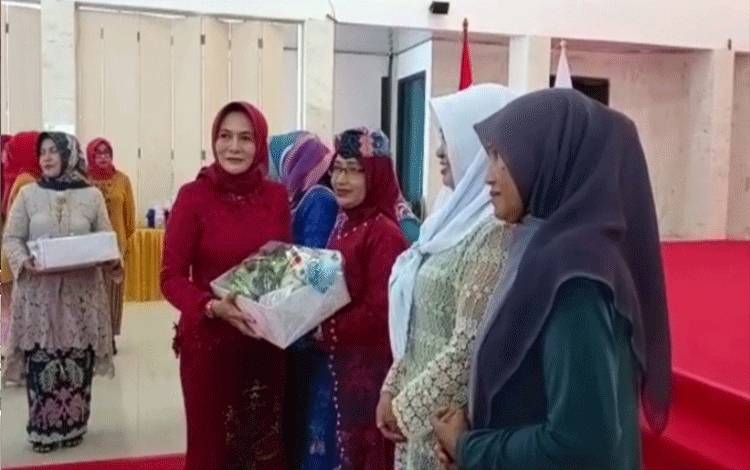 Ketua TP PKK Sukamra, Siti Zulaiha Windu Subagio menyerahkan tali asih pada acara Hari Kartini Ke 144, Kamis, 4 Mei 2023. (FOTO: NORHASANAH)
