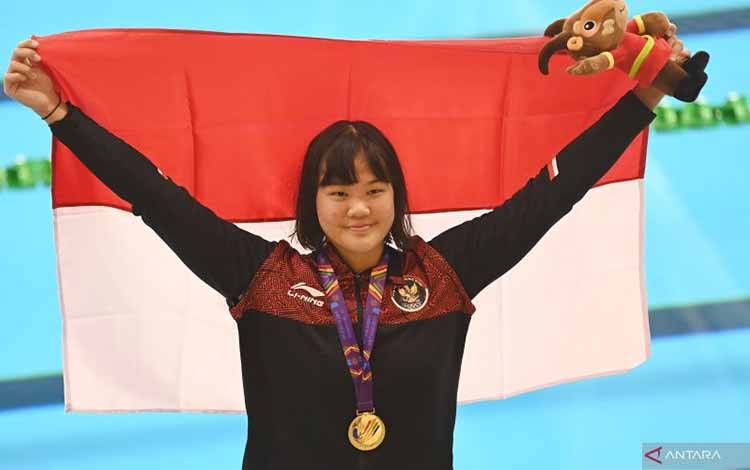 Perenang Indonesia Flairene Candrea Wonomiharjo membentangkan bendera Merah Putih usai upacara pengalungan medali nomor renang 100 meter gaya punggung putri SEA Games 2021 Vietnam di Aquatic Sport Palace, Hanoi, Vietnam, Selasa (17/5/2022). ANTARA FOTO/Aditya Pradana Putra/rwa.