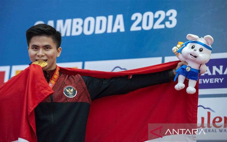 Atlet taolu Indonesia Edgar Xavier Marvelo menggigit medali emas usai upacara penghargaan pemenang final wushu nomor changquan putra SEA Games 2023 di Chroy Changvar International Convention & Exhibition Center, Phnom Penh, Kamboja, Jumat (12/5/2023). Edgar Xavier meraih medali emas pada nomor tersebut dengan skor 9,713. ANTARA FOTO/M Agung Rajasa/tom.