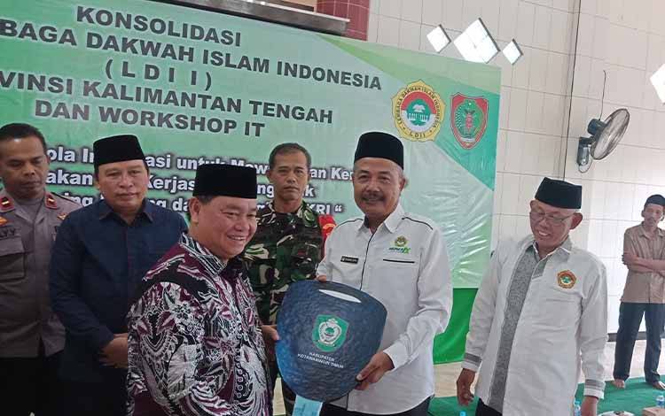 Bupati Kotawaringin Timur Halikinnor menyerahkan kunci ambulan secara simbolis kepada Ketua DPD LDII Kotim, Minggu, 14 Mei 2023. (FOTO: DEWIP)?