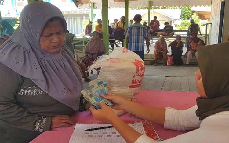 Petugas tengah menyalurkan bantuan sosial CPP, BPS dan PKH kepada para penerima manfaat di Kabupaten Lamandau. (FOTO: HENDI NURFALAH)