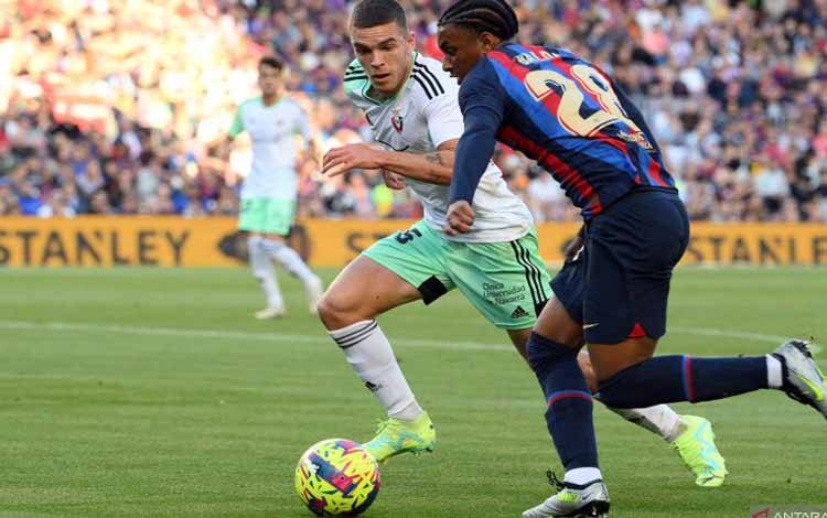 Arsip-Bek Osasuna Diego Moreno (kiri) berduel dengan bek Barcelona Alejandro Balde pada pertandingan Liga Spanyol yang dimainkan di Stadion Camp Nou, Barcelona, Selasa (2/5/2023). (ANTARA/AFP/LLUIS GENE)